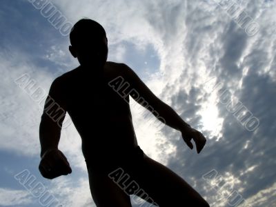 A black silhouette of a young guy in the sky