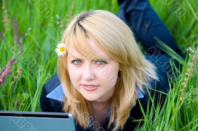 Girl with flower in hair lying on grass #1