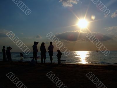 Silhouette of people looking at windsurf
