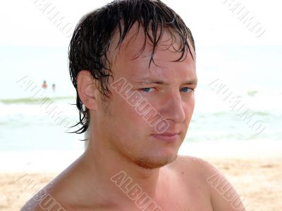 Portrait of a wet young man day at the beach