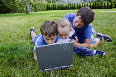 Three cute brothers study on computer