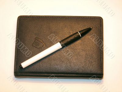 Closed notebook and a pen