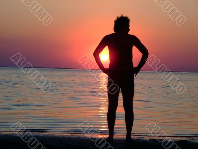 A black silhouette of a young guy on a sunset 1