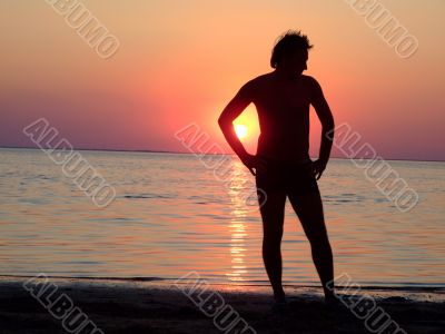 A black silhouette of a young guy on a sunset 2