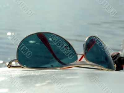 The sunglasses laying on a white surface