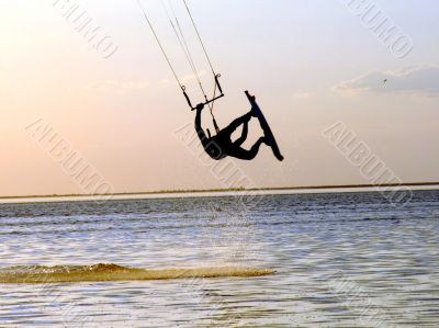 Silhouette of a kitesurf, a flying above water