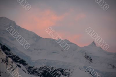 Subtle alpenglow lights snowy mountain