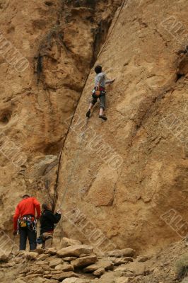 Woman belaying a climber on rock face
