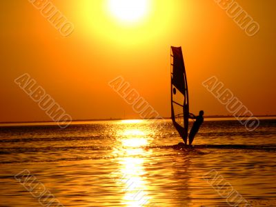 Silhouette of a windsurfer on waves of a gulf