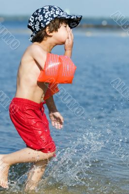 young boy running in water
