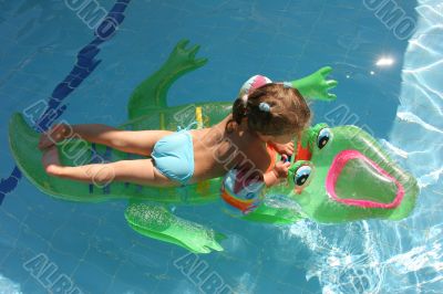Girl swimming on crocodile