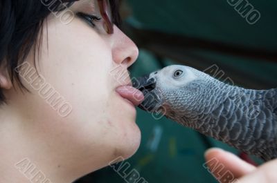 young woman holding a grey parrot