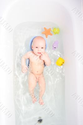 Baby in bath with toys