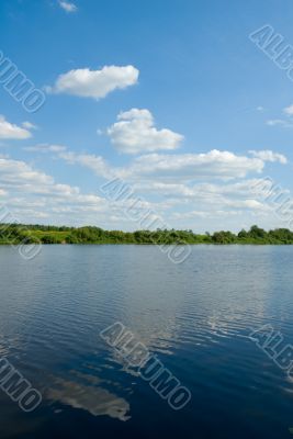 bank of the river, green grass and blue sky