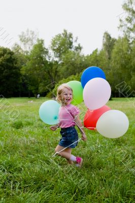 girl with balloon runs on lawn