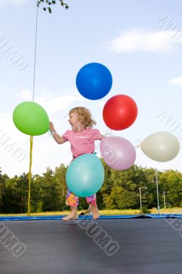 girl with balloons jumping on trampoline