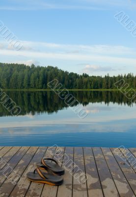 pair of slippers on a pier of the lake