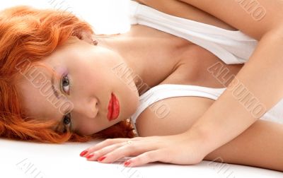 laying redhead in white shirt