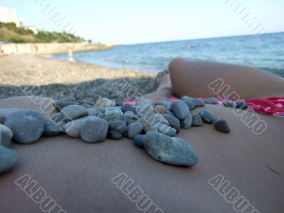 The girl in a pebble on a beach