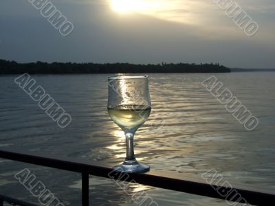 Glass of white wine on a background of a sunset