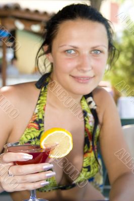 Young beautiful smiling woman drinking cocktail
