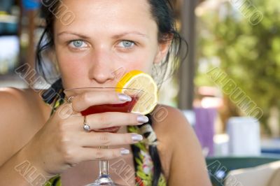 Young beautiful smiling woman drinking cocktail