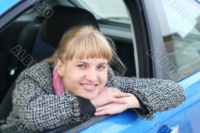 Blonde girl in a blue car