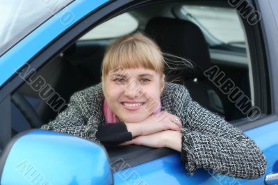 Blonde girl in a blue car