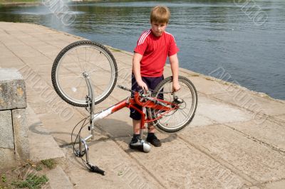 boy repairs the bicycle