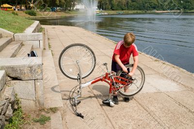boy repairs the bicycle