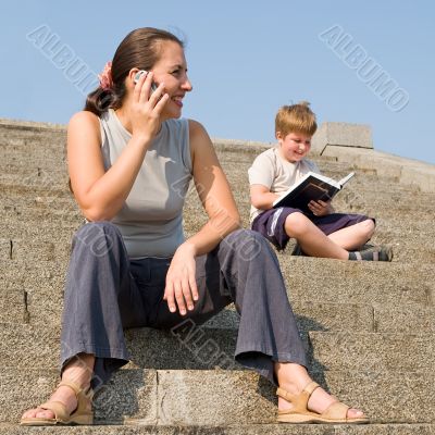 girl with mobile. boy reads book