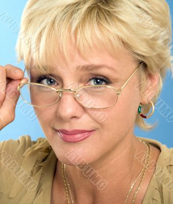 blonde adult businesswoman holding glasses and looking through
