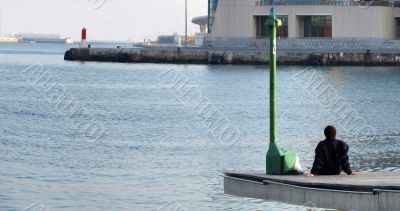 The man sitting on a pier
