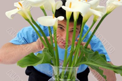 Man peeking through flowers