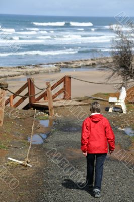 Red parka woman walking to beach