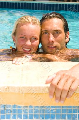 attractive couple relaxing by the pool