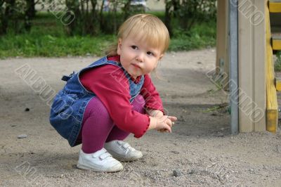 Beautiful baby girl playing with sand