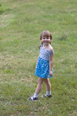 Smiling little cutie standing on the grass