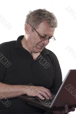 Senior man answering on e-mail from laptop