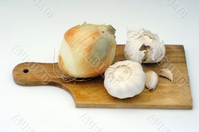 Garlic and onion on a wooden plate