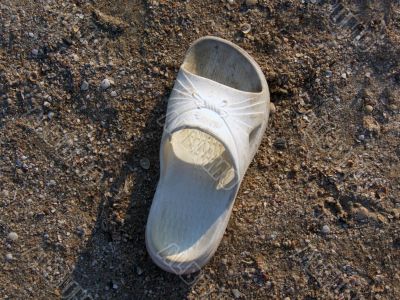 The lost white sandal laying on the beach