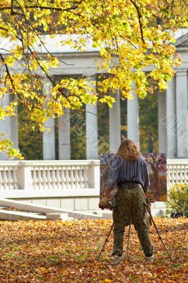 Painter in autumn park