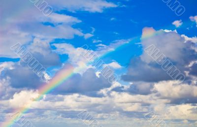 rainbow in the sky between the clouds