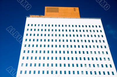 bright white office tower against blue sky