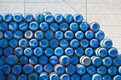 big pile of stacked blue barrels