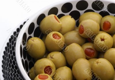 Green olives in bowl with dots.