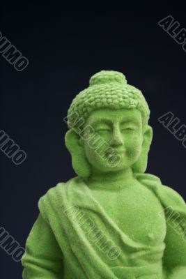 Green buddha, black background.