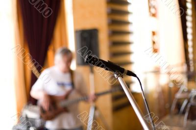Microphone on tripod with guitarist on background #1