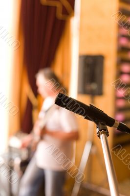Microphone on tripod with guitarist on background #2