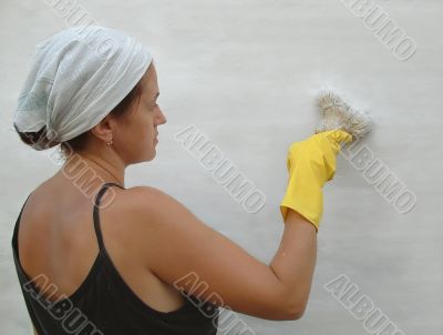 The woman paints a wall